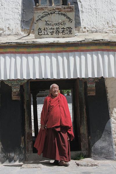 044 An old monk stepping out of the Sera Retirement Home.jpg